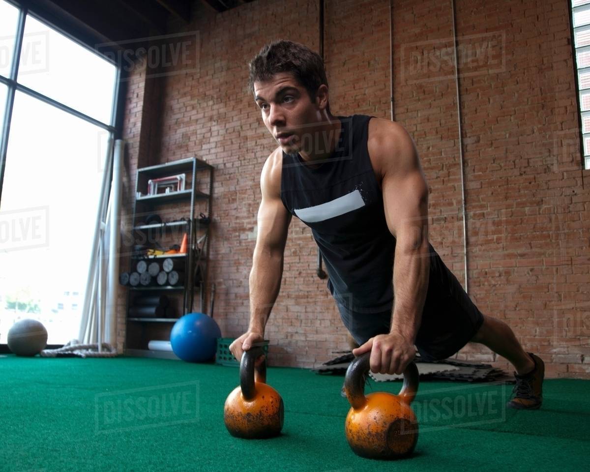Male bodybuilder using kettlebells Stock Photo Dissolve