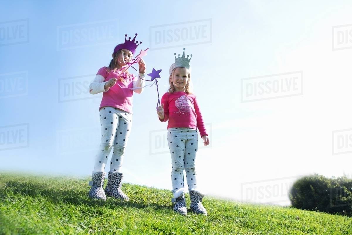 Two young sisters dressed up as fairies standing on hill Royalty-free stock photo