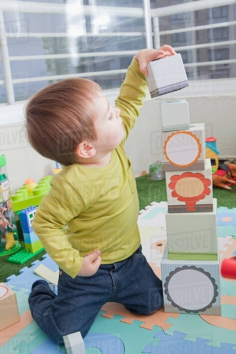 Baby boy stacking playing blocks at home Stock Photo Dissolve