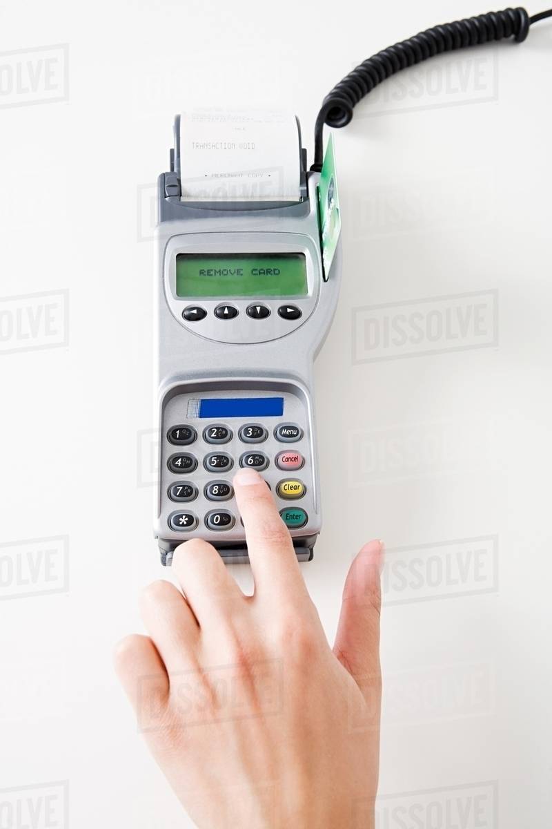 Woman using a chip and pin machine Stock Photo Dissolve