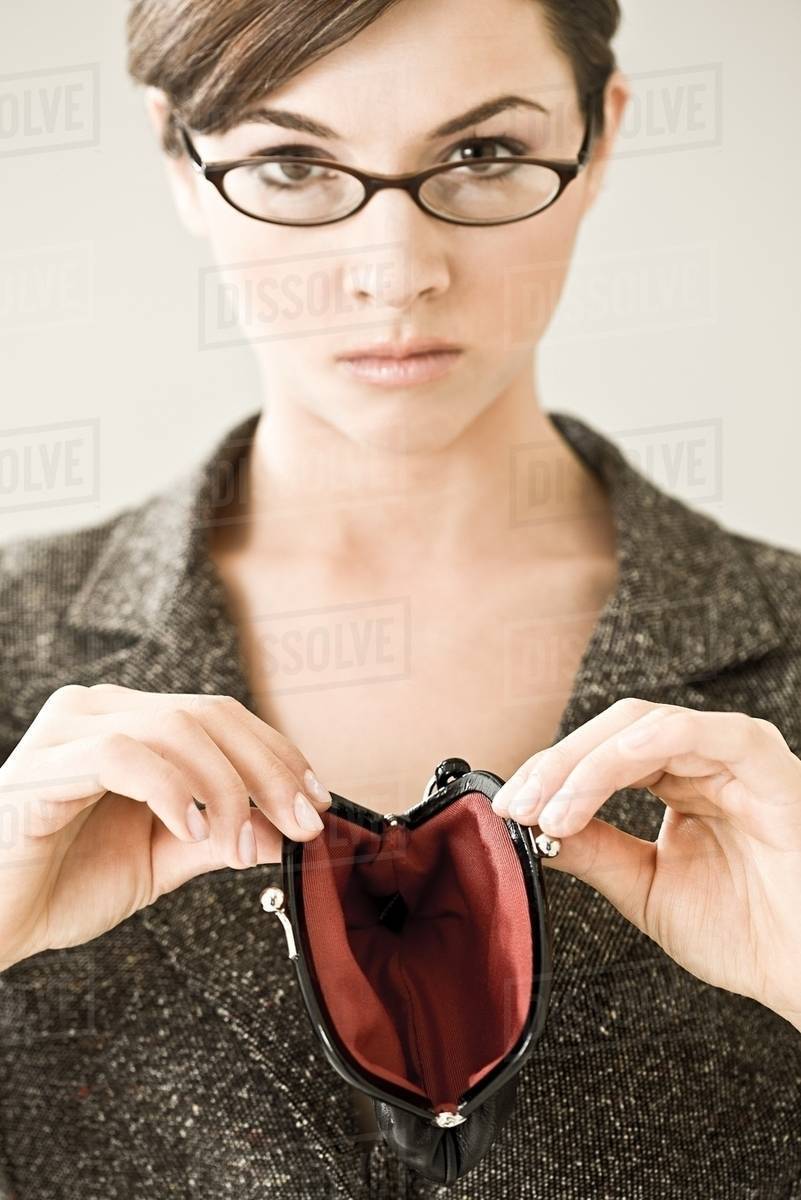 A woman holding an empty purse Stock Photo Dissolve