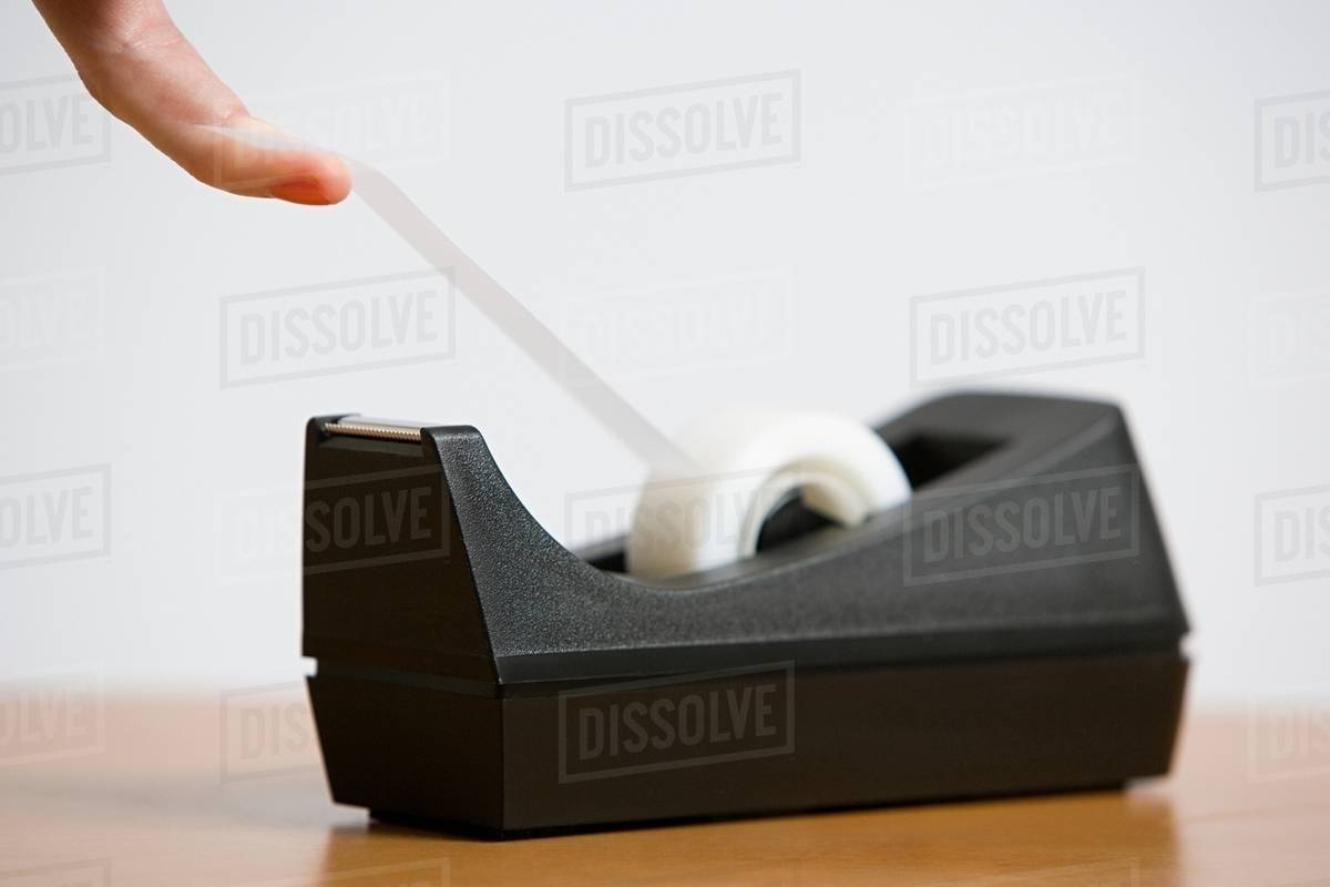 A person holding adhesive tape Stock Photo Dissolve