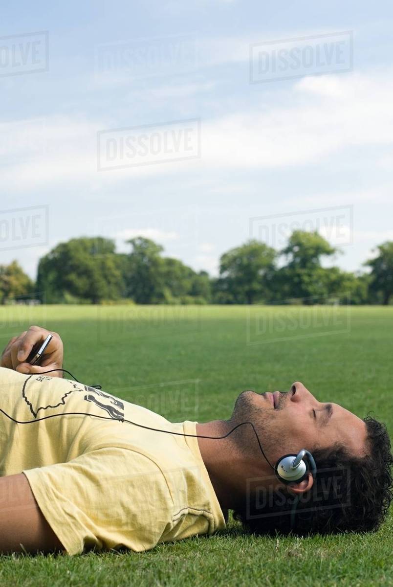 Man wearing headphones and lying down Stock Photo Dissolve