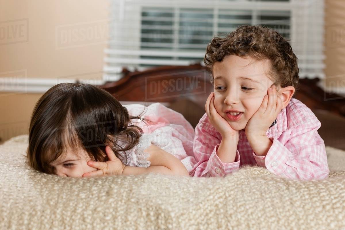 Children laying on bed Stock Photo Dissolve