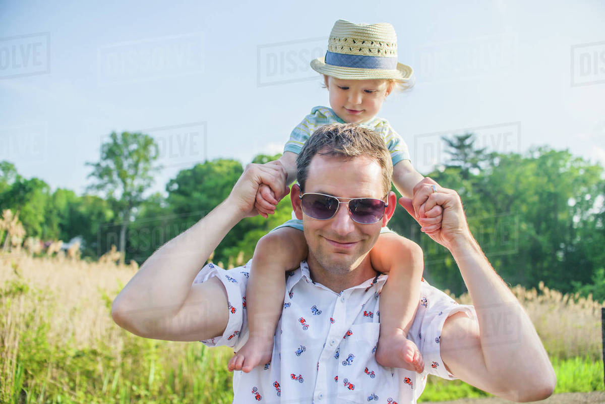 Father carrying baby boy on shoulders Stock Photo Dissolve