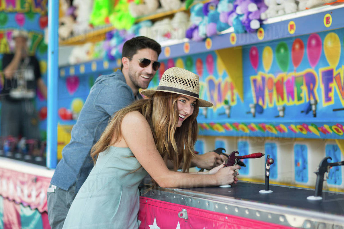 Couple at fairground shooting gallery, Coney island, Brooklyn, New York