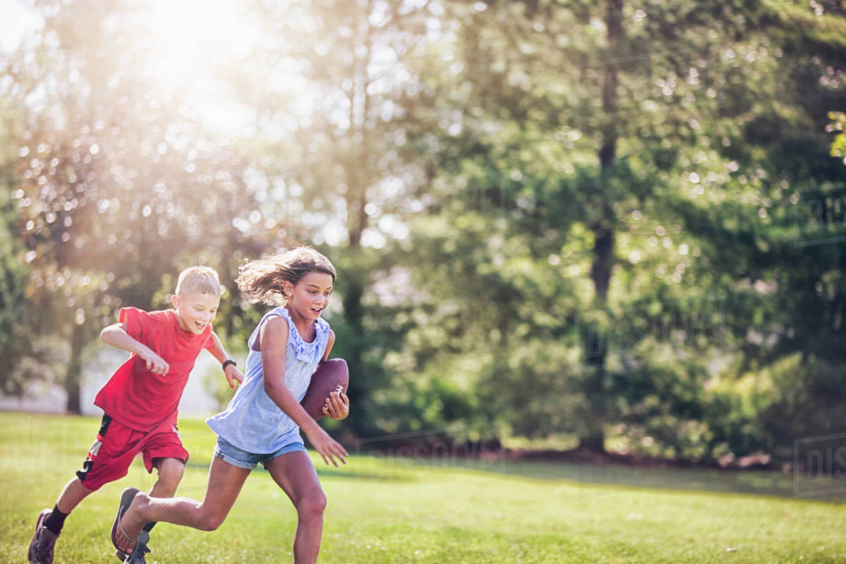 Girl and boy playing American football Royalty-free Stock Photo
