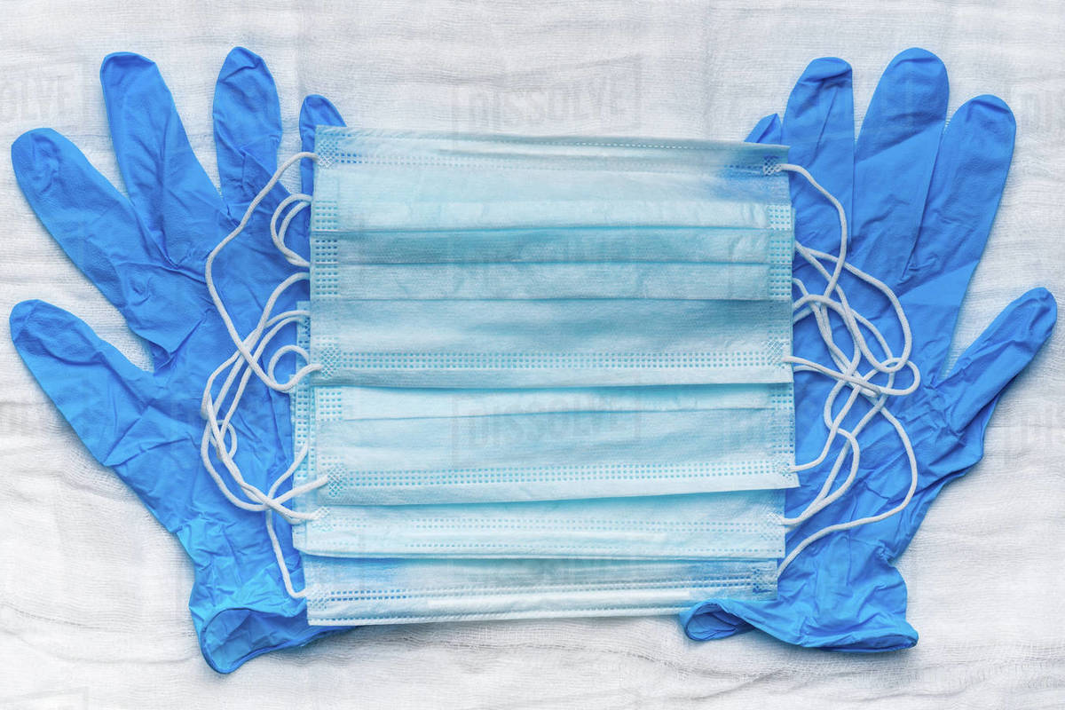 Lot medical respiratory face masks on blue gloves as background. World