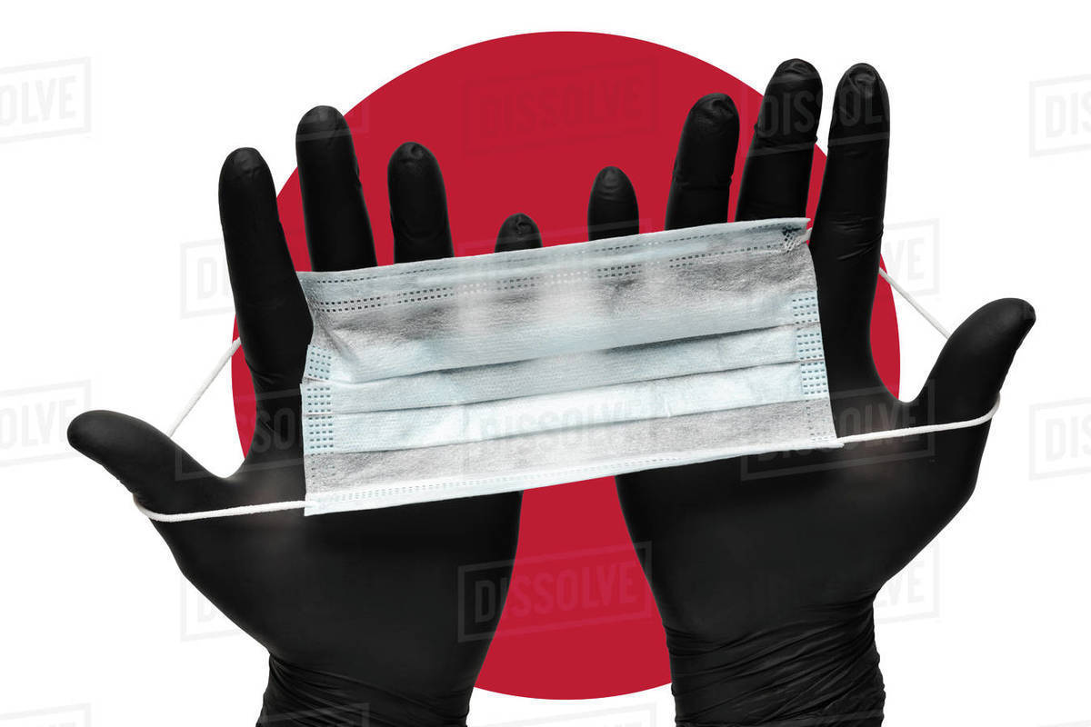 Doctor holds face mask in hands in black medical gloves on background