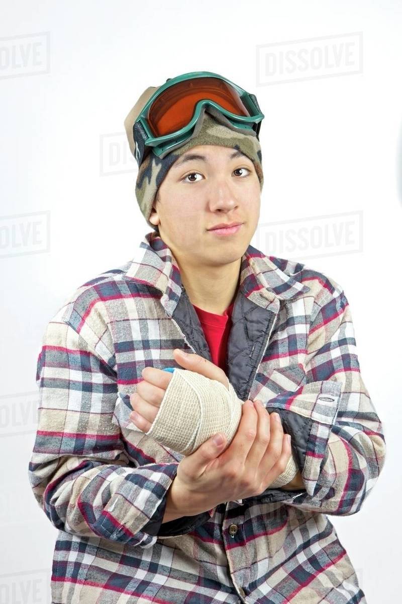 Portrait of a teenage boy showing his broken wrist all bandaged up