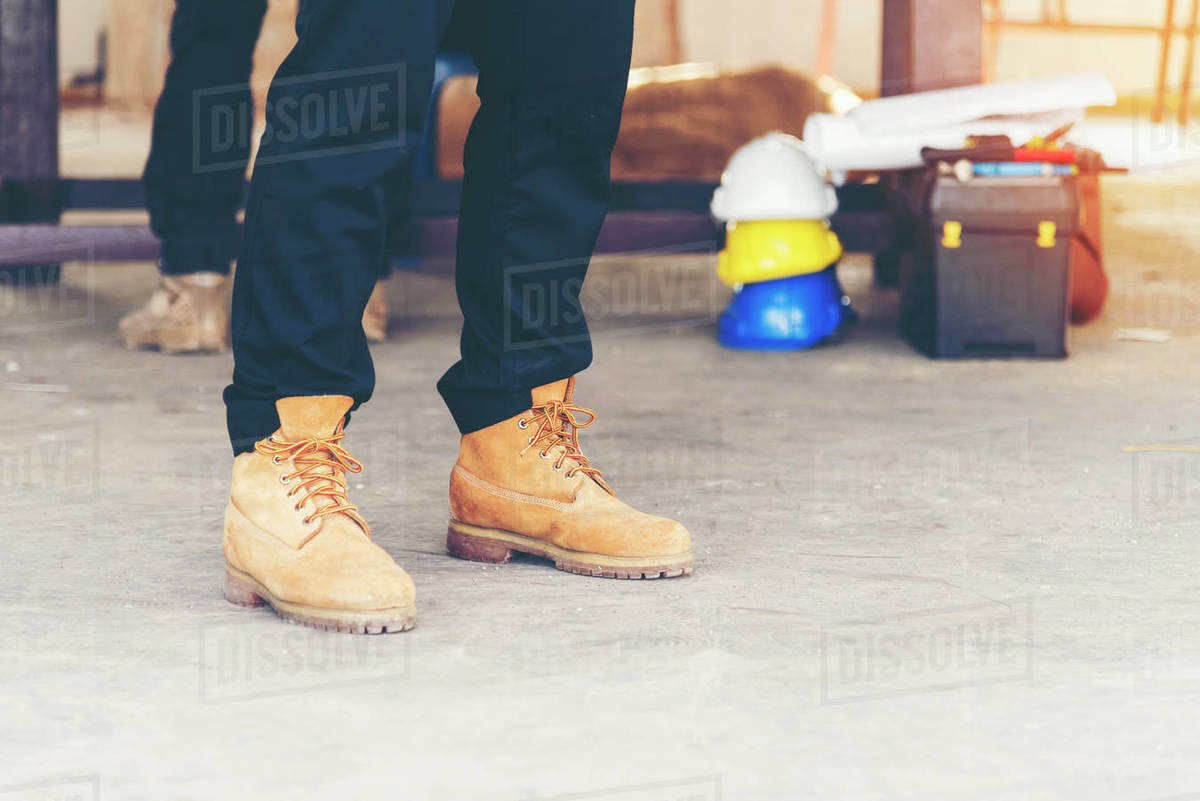 Footwear concept.Handsome man wear jeans knelt down to do up his