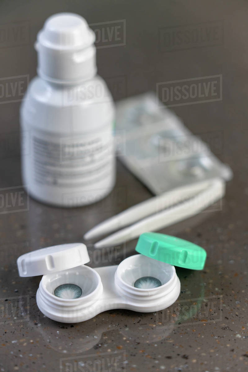 Container with green contact lenses on white background Stock Photo