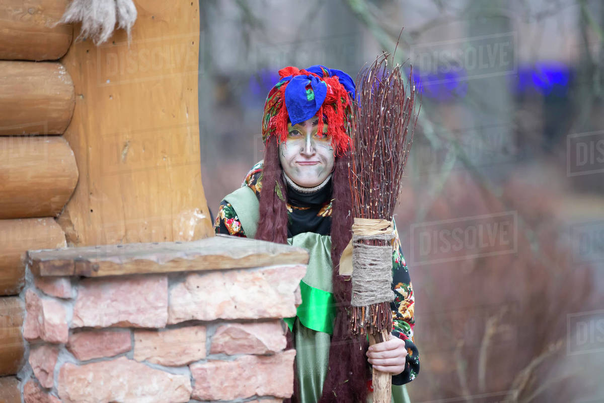 Baba Yaga with a broom near a wooden hut. Royalty-free stock photo