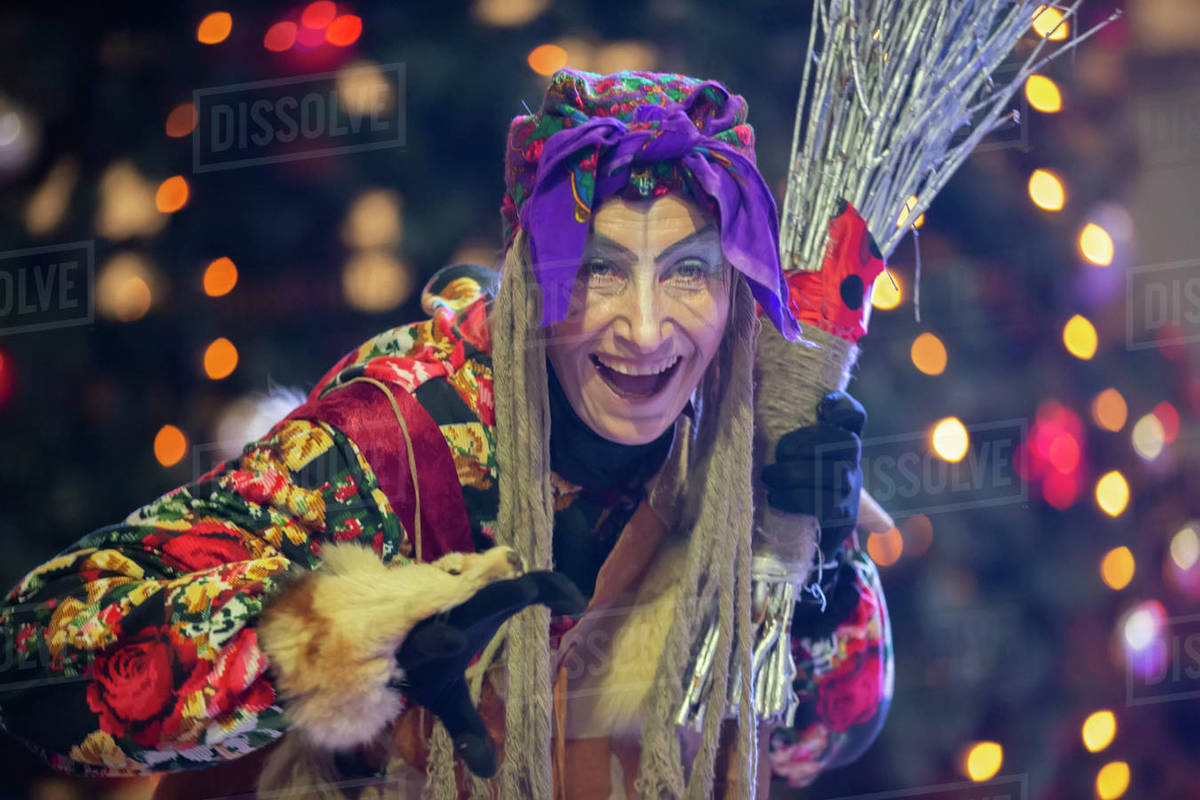 Baba Yaga with a broom on the background of the Christmas tree. Royalty-free stock photo