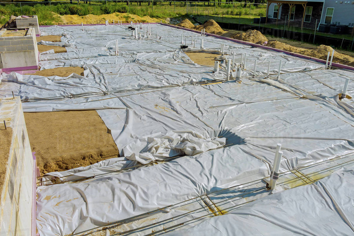 Laying in the a trench ground PVC pipes before pouring concrete Stock