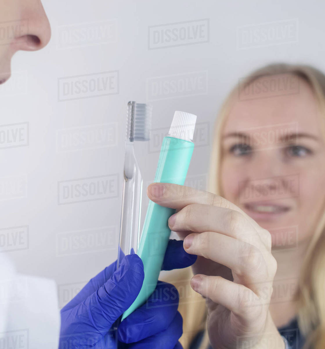 The dentist advises the girl on how to brush her teeth properly. The