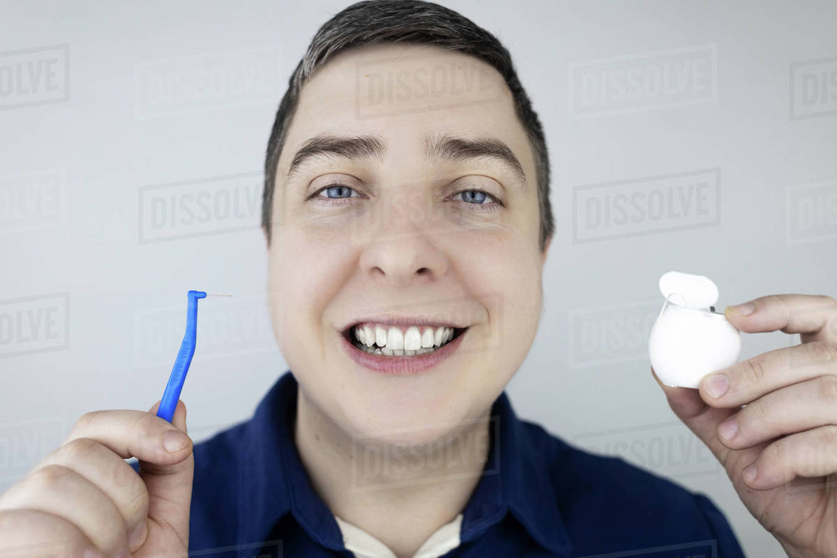 Interdental brush. A man shows a brush for cleaning the interdental