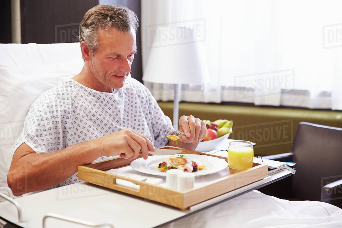 Male Patient In Hospital Bed Eating Meal From Tray Stock Photo Dissolve