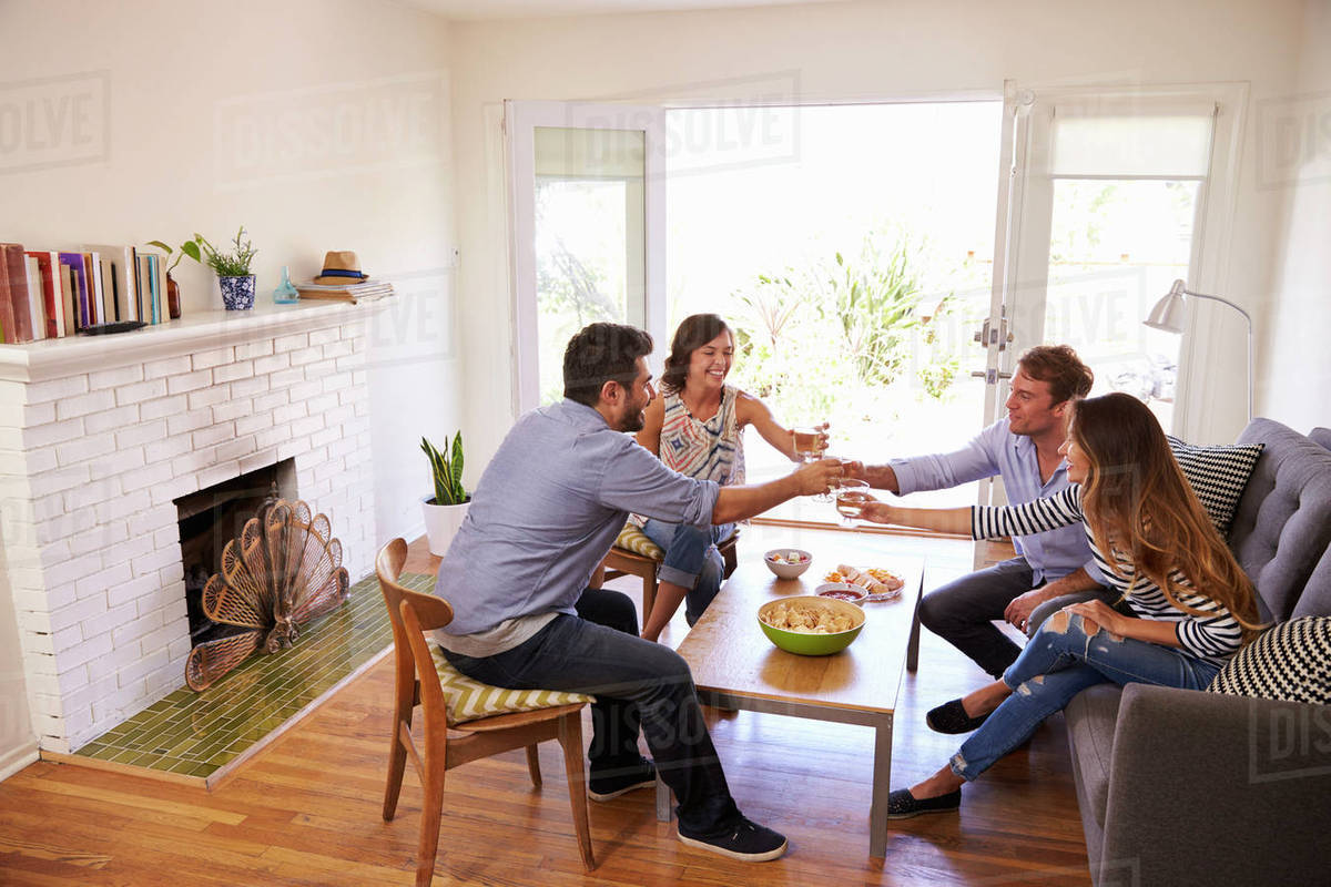 Couple entertaining friends at home Stock Photo Dissolve