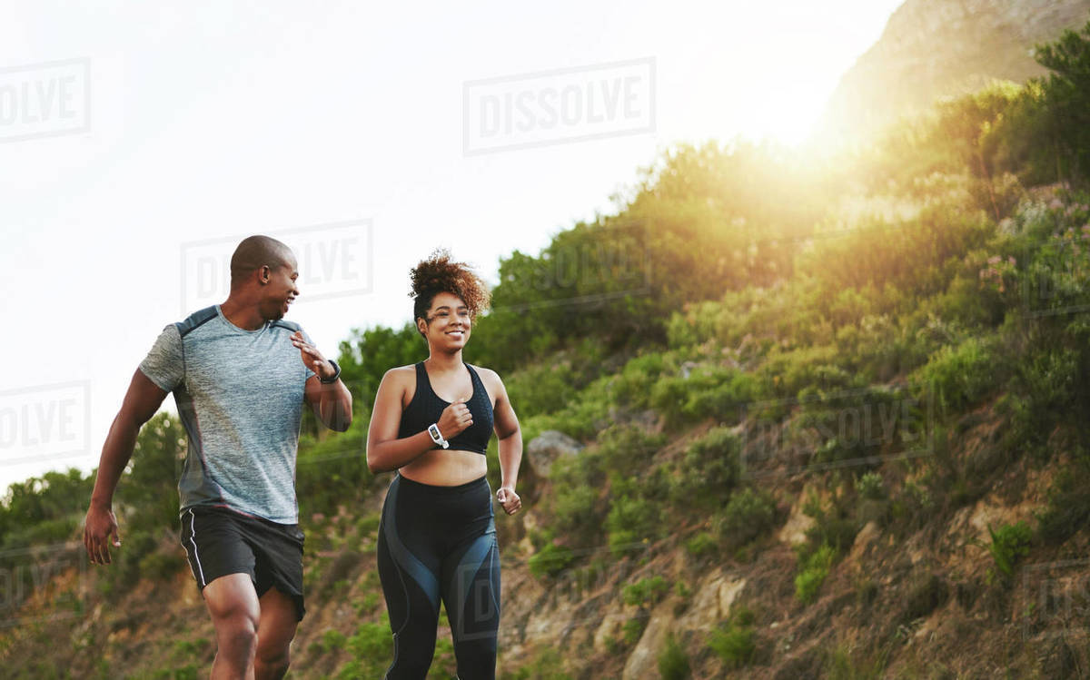 Fitness, nature and couple walking by a mountain training for a
