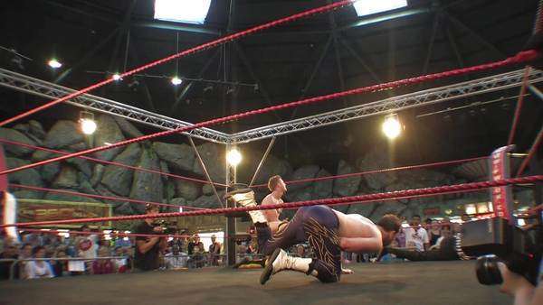 Pro wrestling match - wrestler misses a top rope splash dive and hits ...