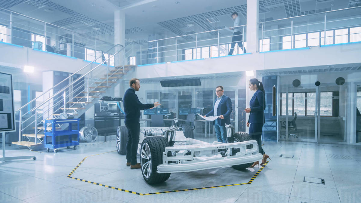 Automotive Design Engineers Talking while Working on Electric Car