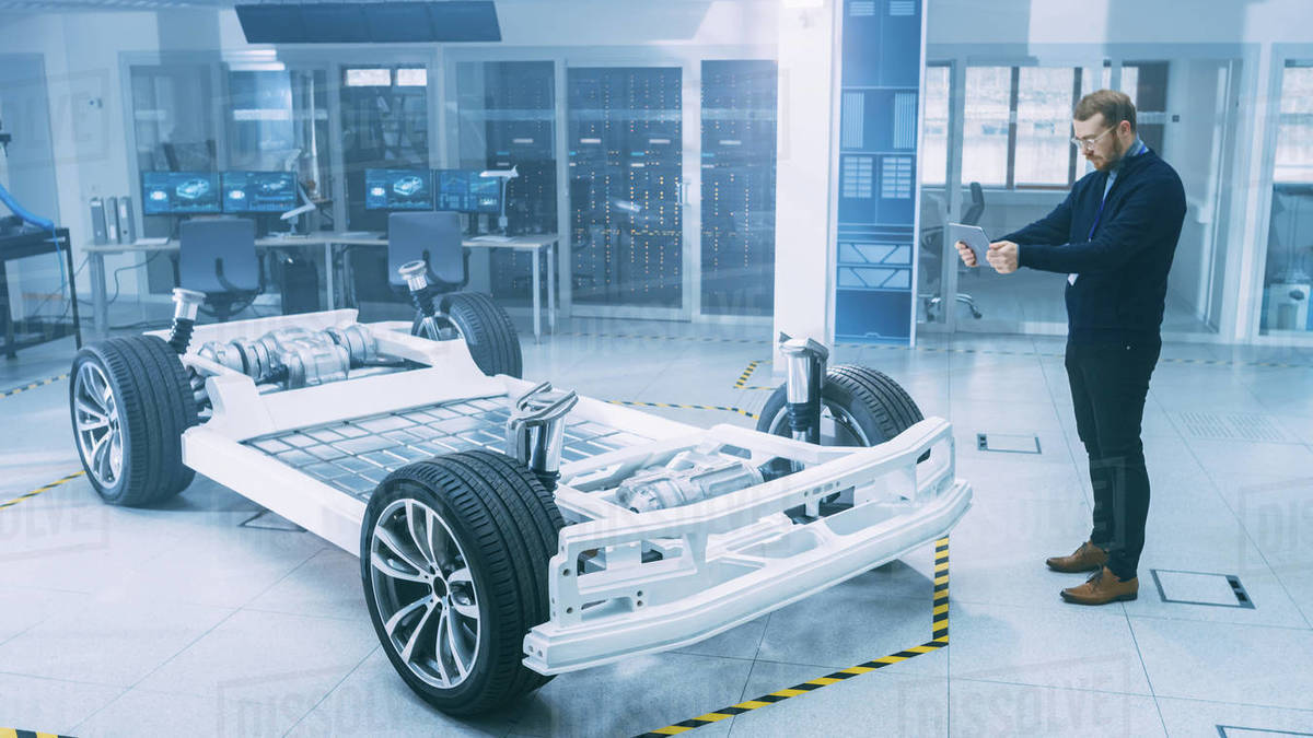 Engineer with Glasses and Beard Scans Electric Car Chassis Prototype