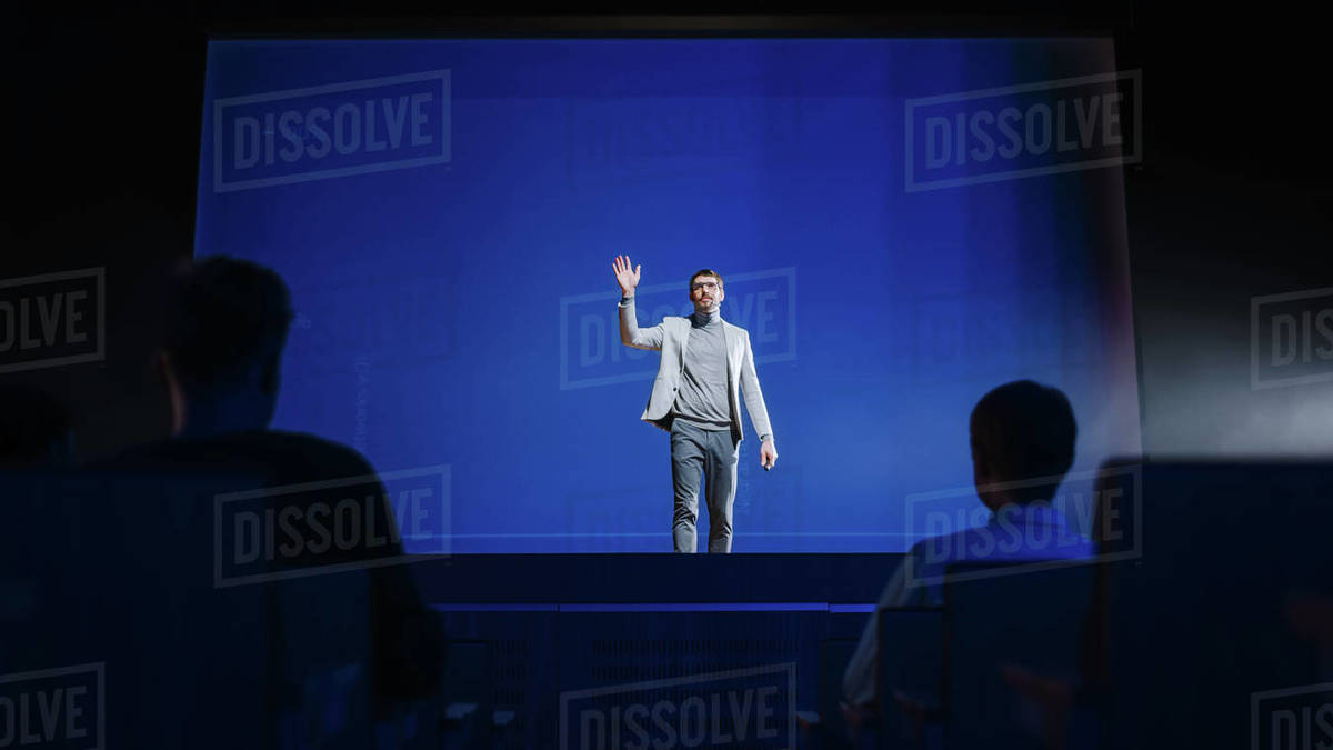 Successful Speaker Stands on Stage and Does New Product Presentation