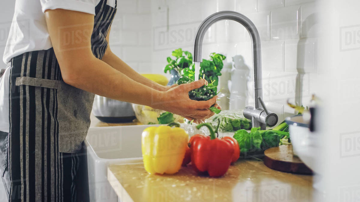 Close Up Shot of a Man Washing Green Spinach Leaves with Tap Water
