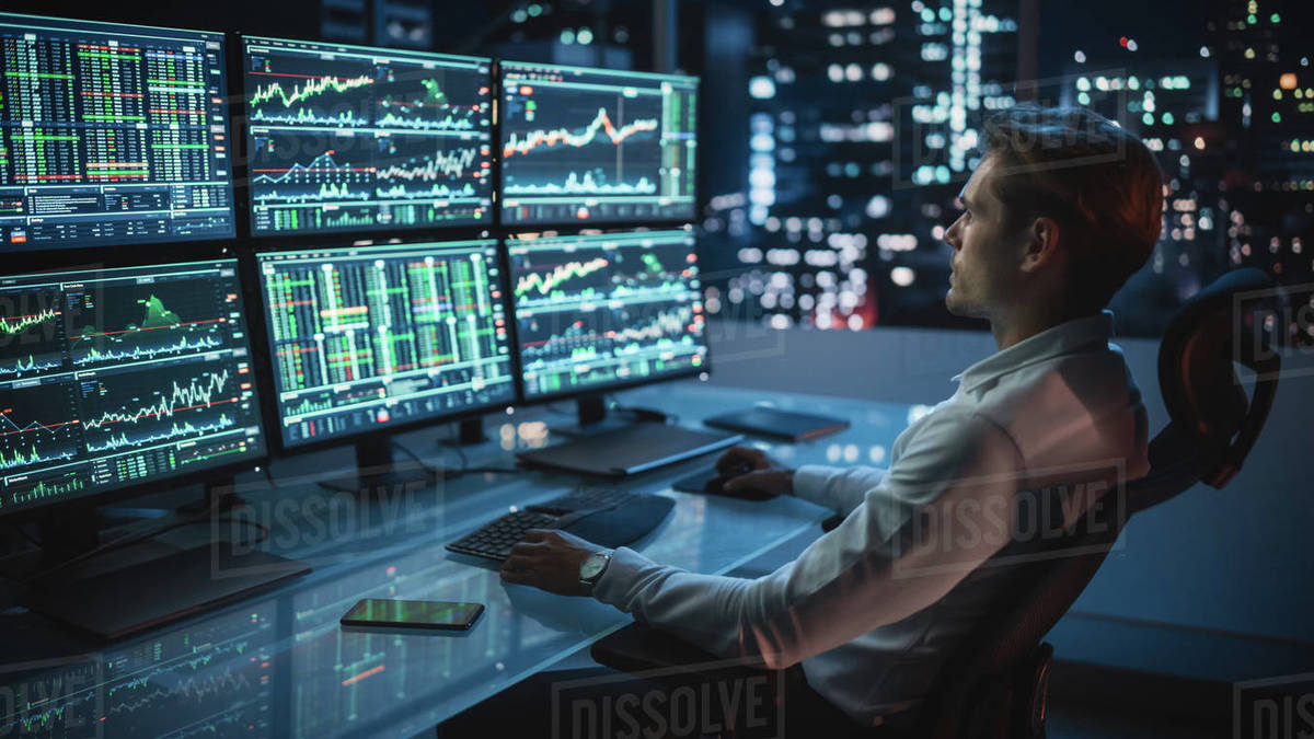 Financial Analyst Working on a Computer with MultiMonitor Workstation