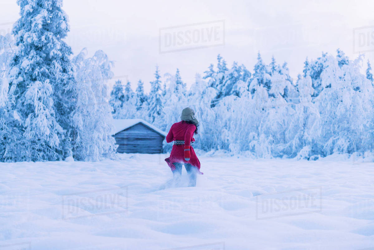 Woman running through snow Stock Photo Dissolve