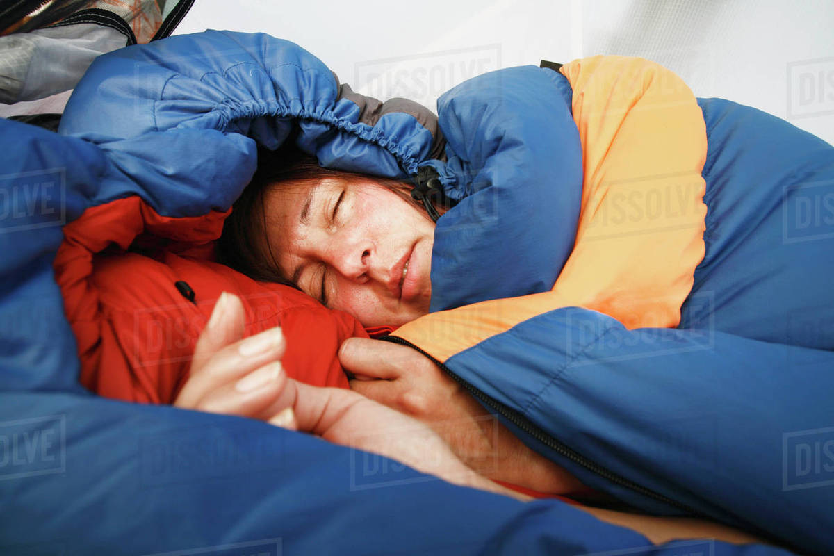 Woman sleeping in sleeping bag Stock Photo Dissolve