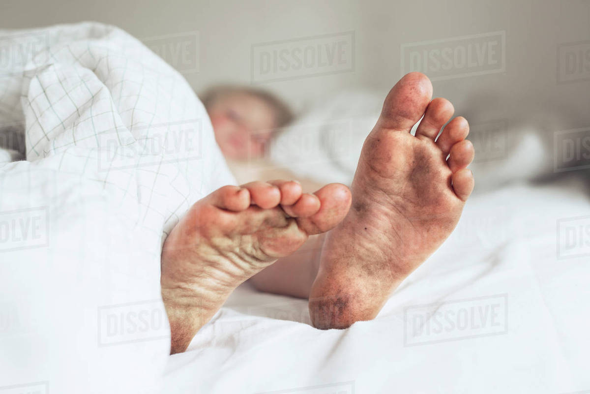 Childs dirty feet in bed Stock Photo Dissolve