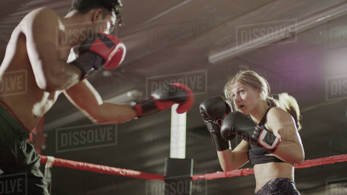 Close up of female boxer protecting her face standing in boxing ring
