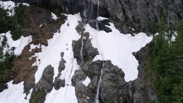 Drone Flying Up Massive Mountain Cliff Environment With Spring Snow Runoff In Waterfalls Royalty Free Drone Flying Up Massive Mountain Cliff Environment With Spring Snow Runoff In Waterfalls Royalty Free