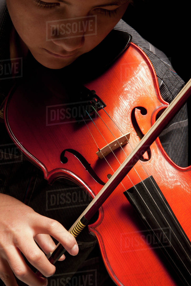 Boy playing violin; Edmonton, Alberta, Canada Stock Photo Dissolve