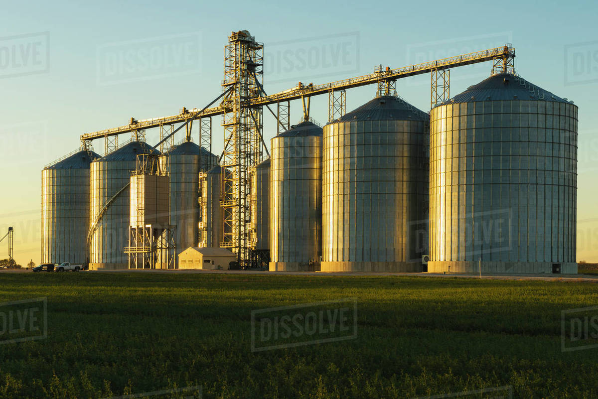 A Large Grain Storage Facility Is Lit By The Last Rays Of The Sun In