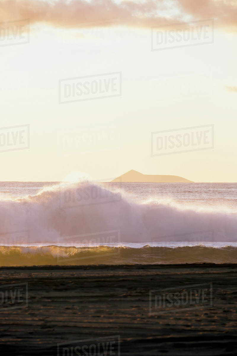 Golden surf visible from Barking Sands Beach in Kekaha with Lehua