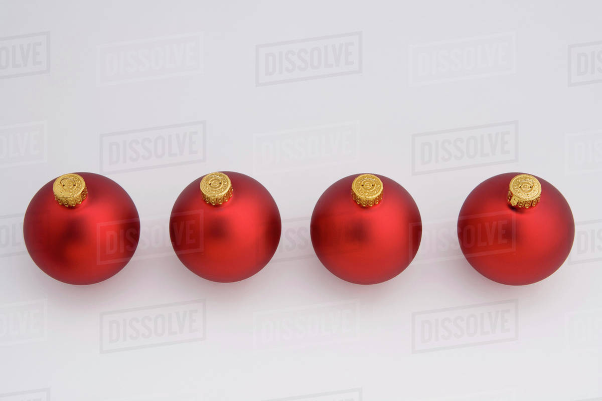 four red christmas balls in a diagonal line on white background studio portrait - Red Christmas Balls four red christmas balls in a diagonal line on white background studio portrait - Red Christmas Balls