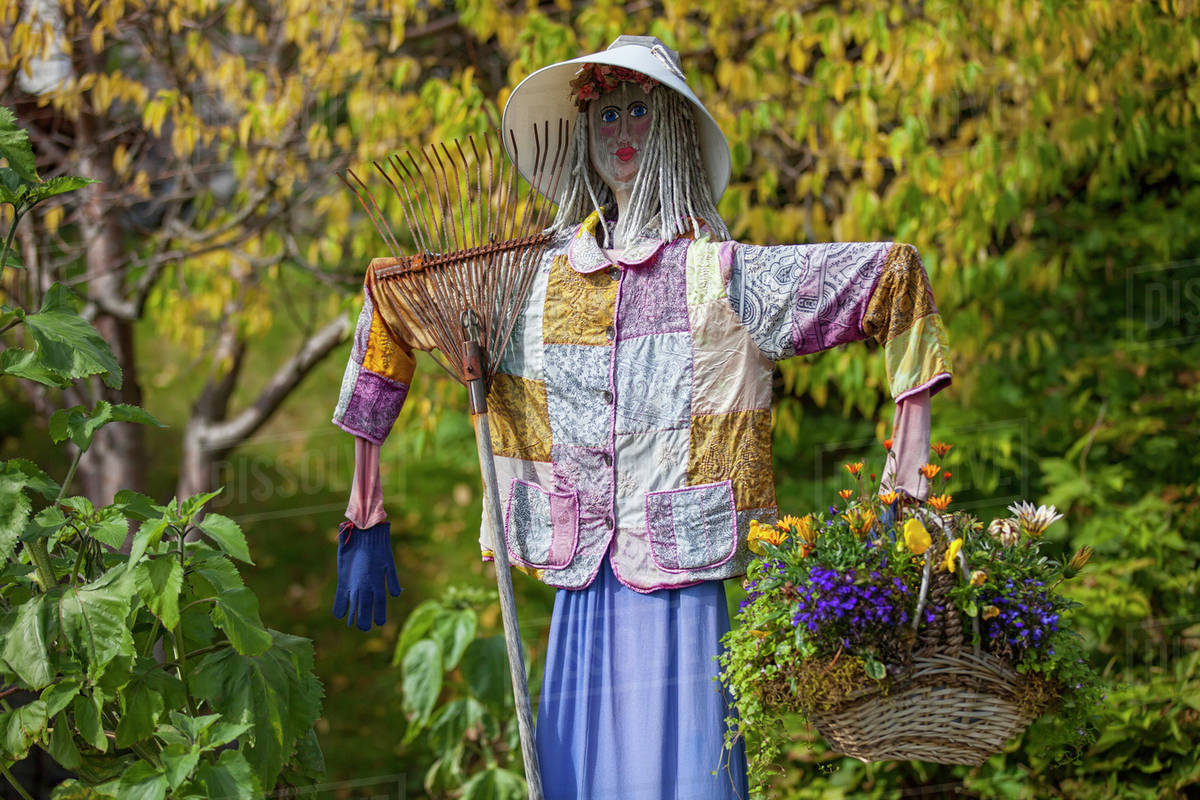 A female scarecrow holding a flower basket and rake;Kodiak alaska ...