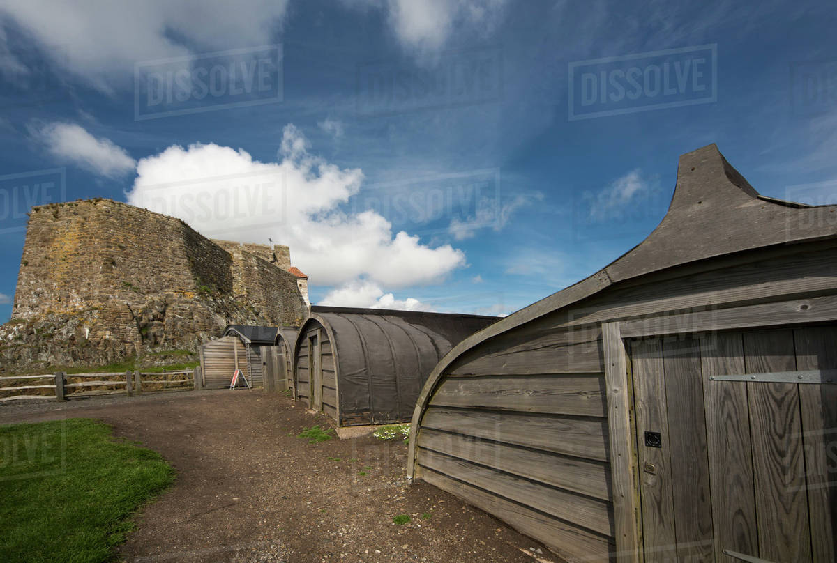 rounded wooden buildings and a stone building on holy island