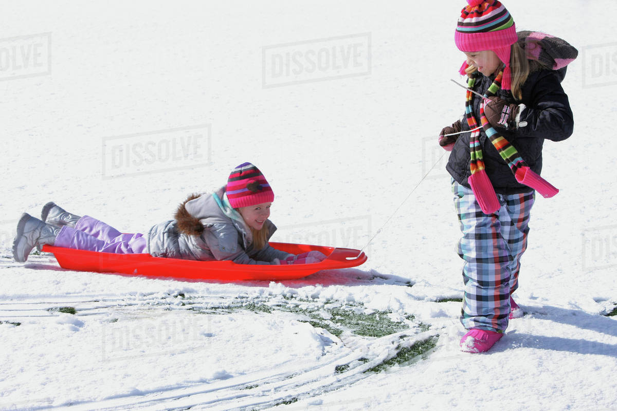 Two Girls Playing In The Snow; Troutdale, Oregon, United States of