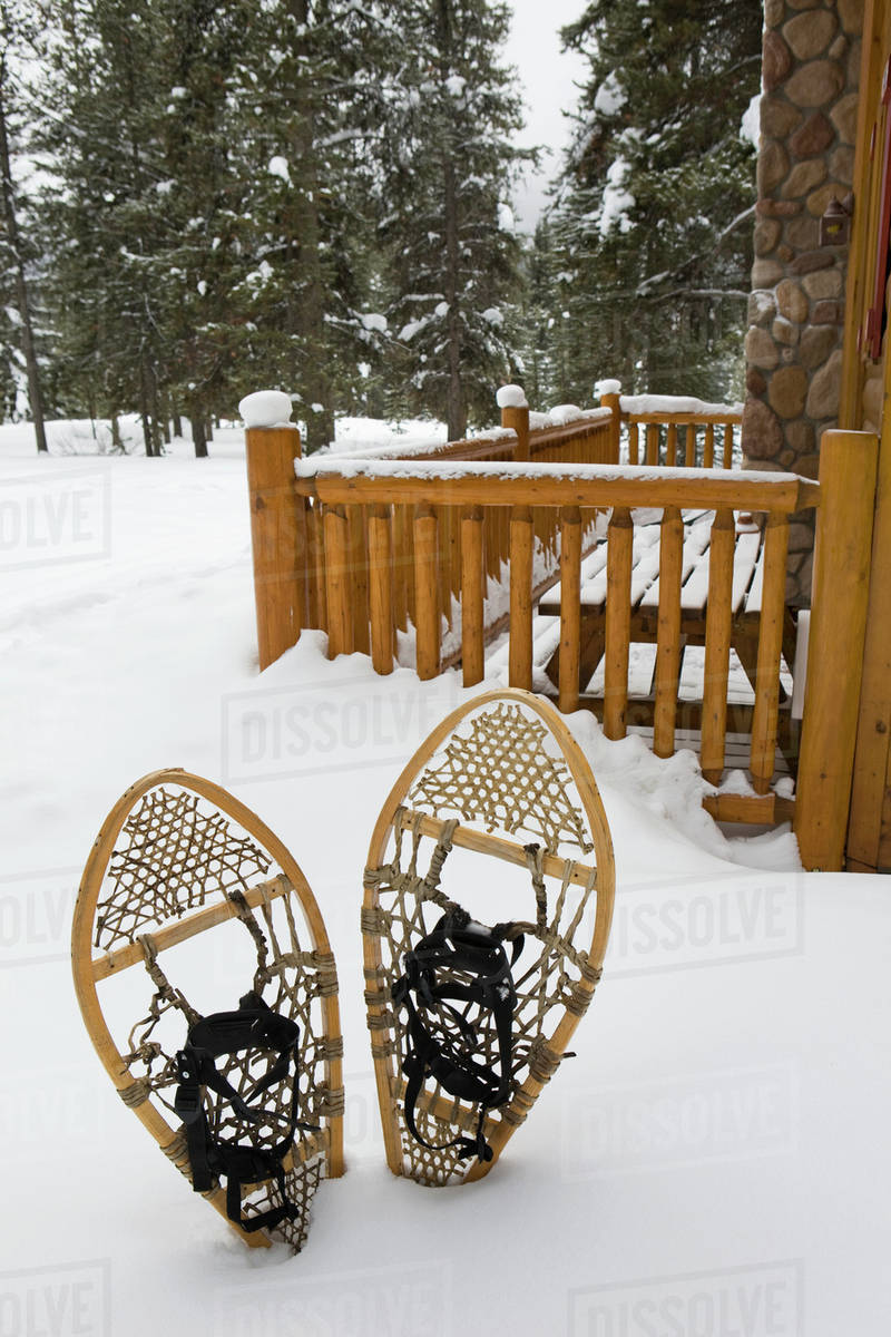 Traditional bed Snowshoes In The Snow Next To A Log Cabin Patio