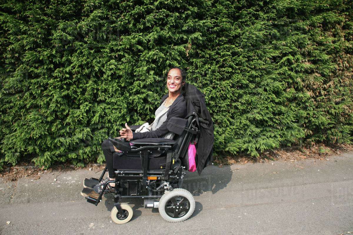 Woman Operating Her Wheelchair; Bolton, Lancashire, England Stock
