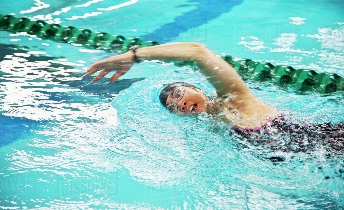 A Woman Wearing A Cap And Goggles Swims The Front Stroke In A Lane At A Swimming Pool; Edmonton