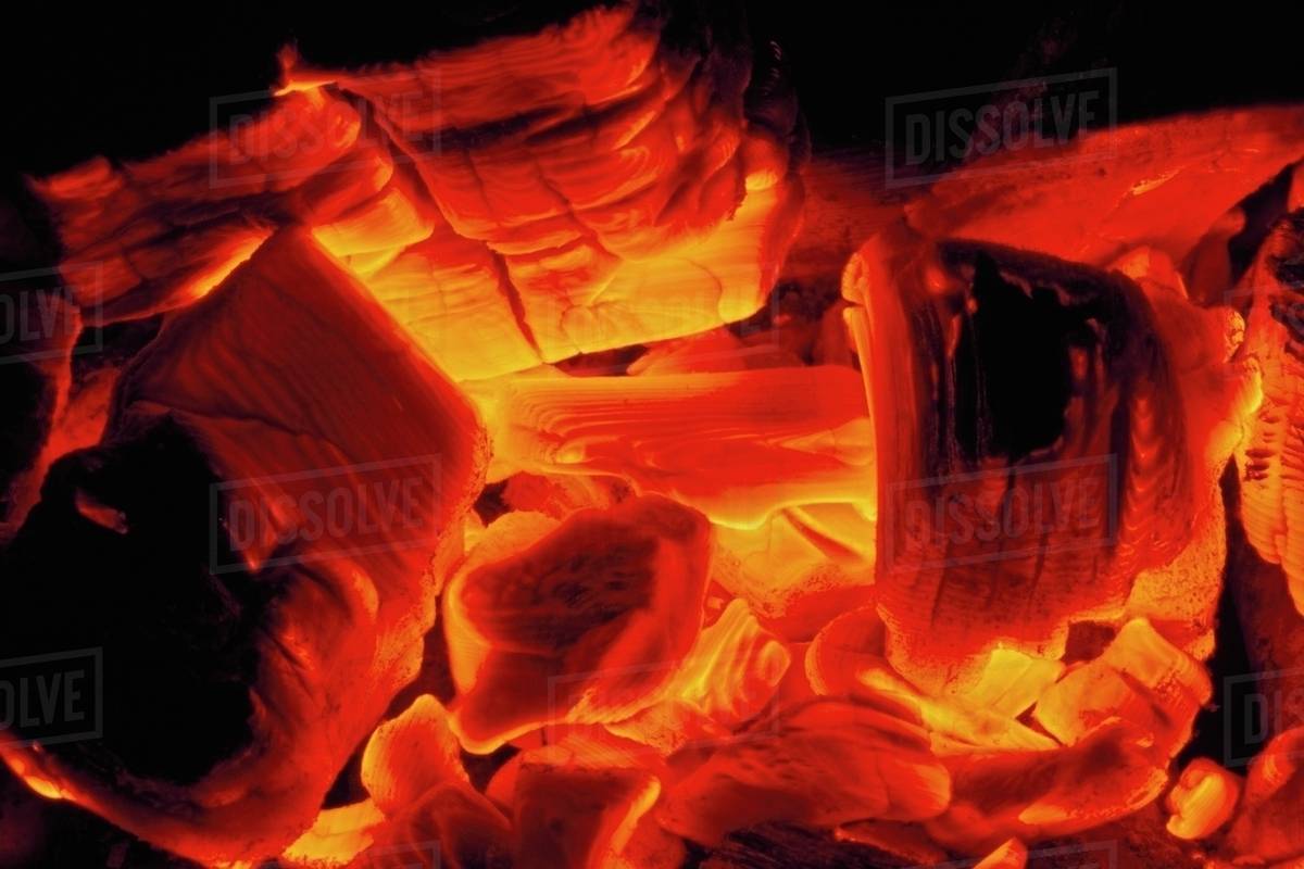 Hot Coals From Wood Fire Glow Yellow To Red To Orange; New Mexico, Usa Stock Photo Dissolve