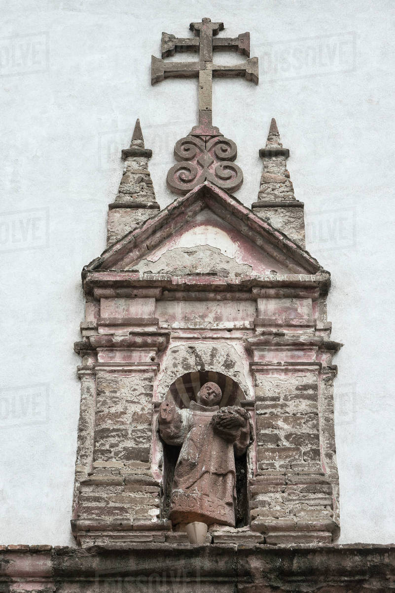 Stone Sculpture Of A Man Standing In A Doorway Of A Building; San