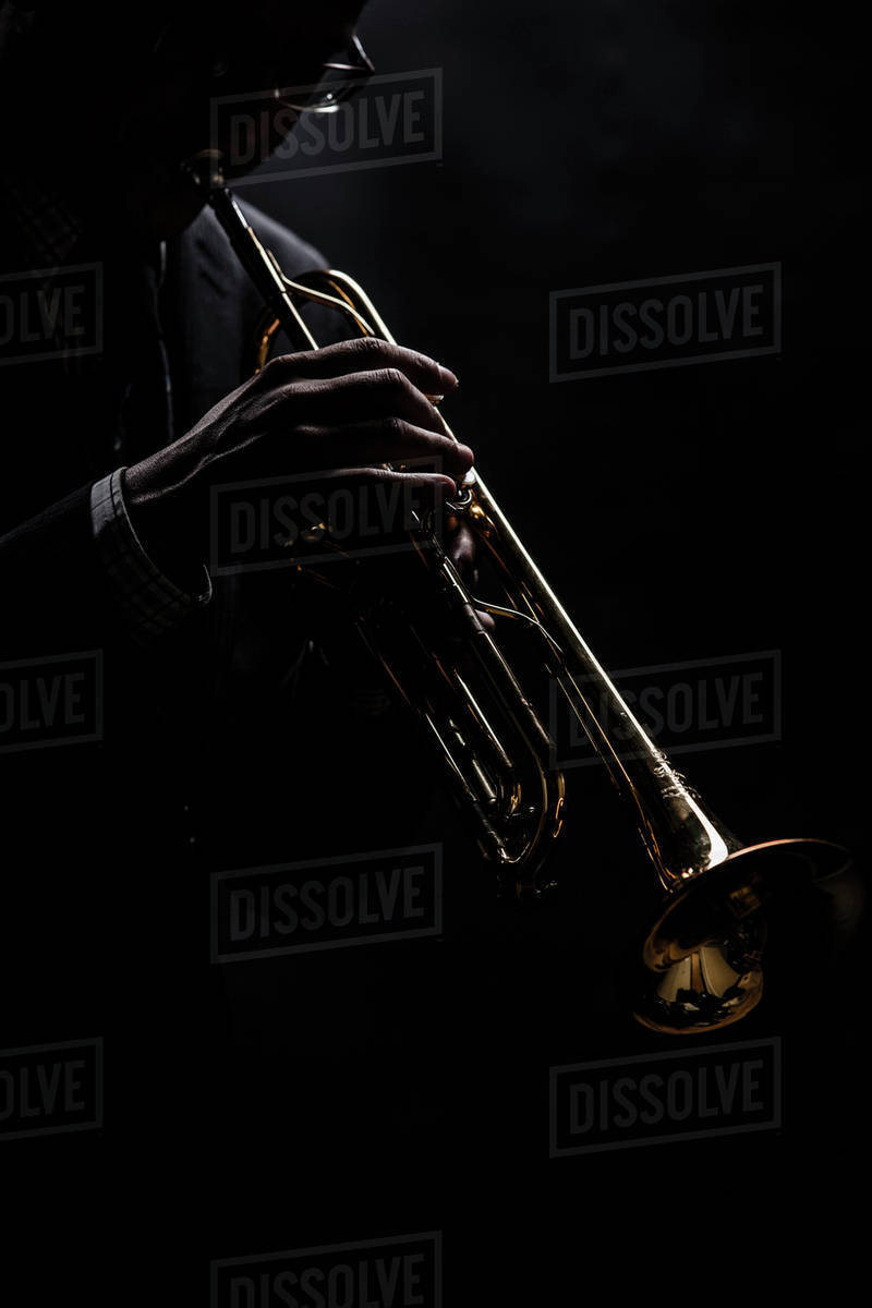 Musician playing trumpet over black background Stock Photo Dissolve