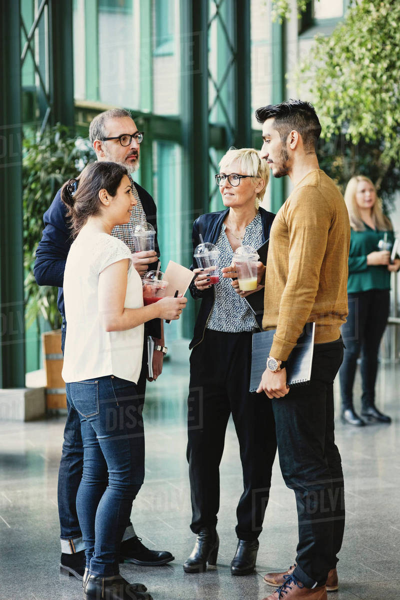 Full length of business people having discussion in creative office