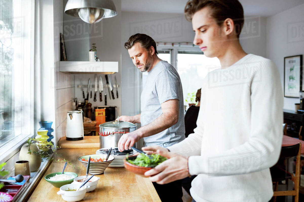 Father and son cooking in kitchen Stock Photo Dissolve